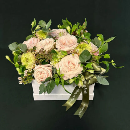 Valentine's Day elegant light pink rose box with lush greenery and decorative ribbon, perfect for a romantic gift.